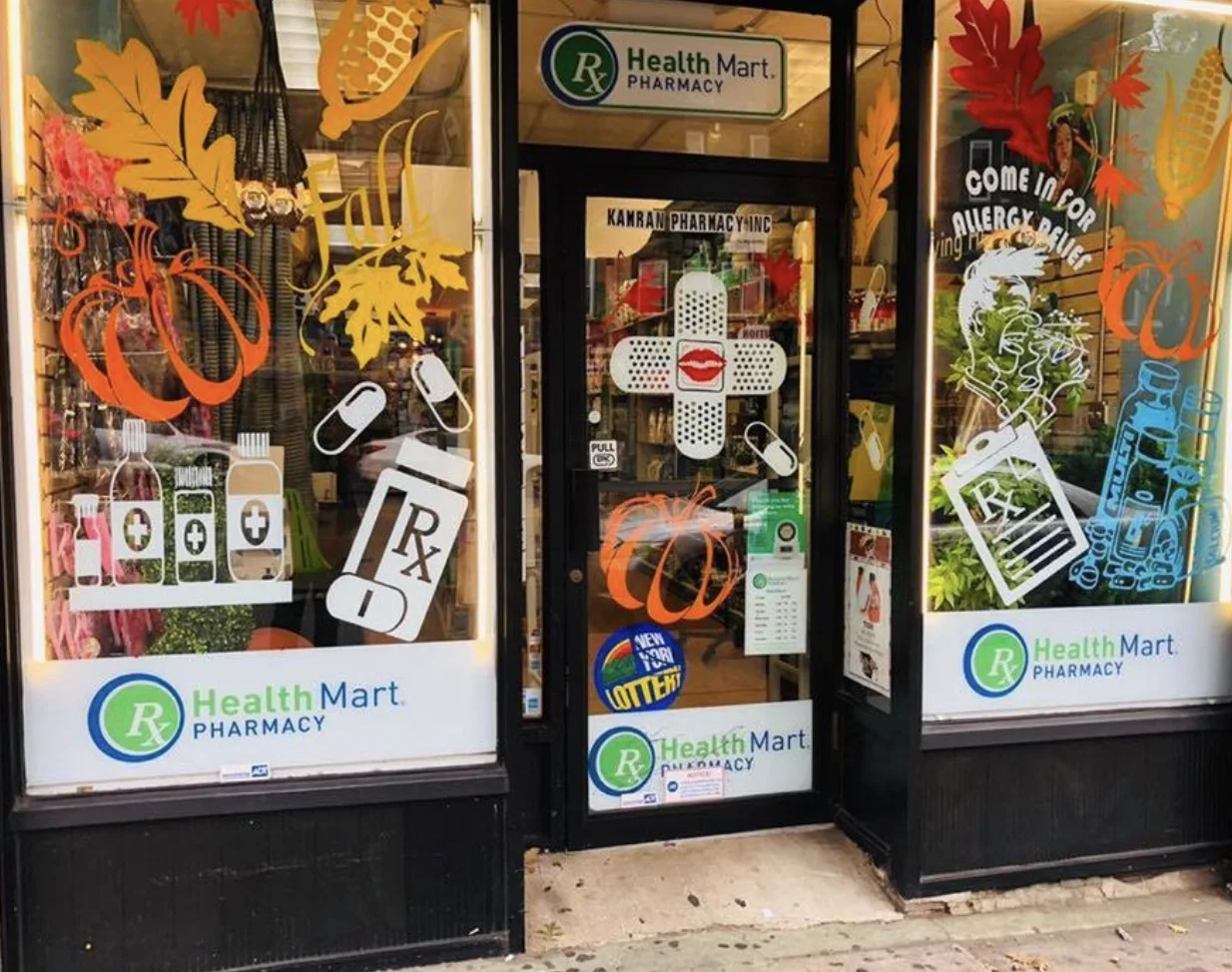 Family Pharmacy storefront on Flatbush Avenue with seasonal artwork painted on the windows